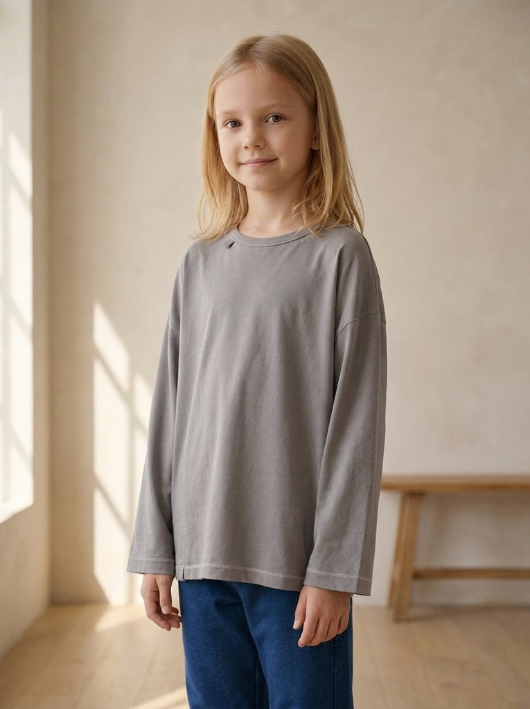 Girl wearing a stone grey sensory friendly longsleeve for kids in label-free bamboo cotton by Blusss